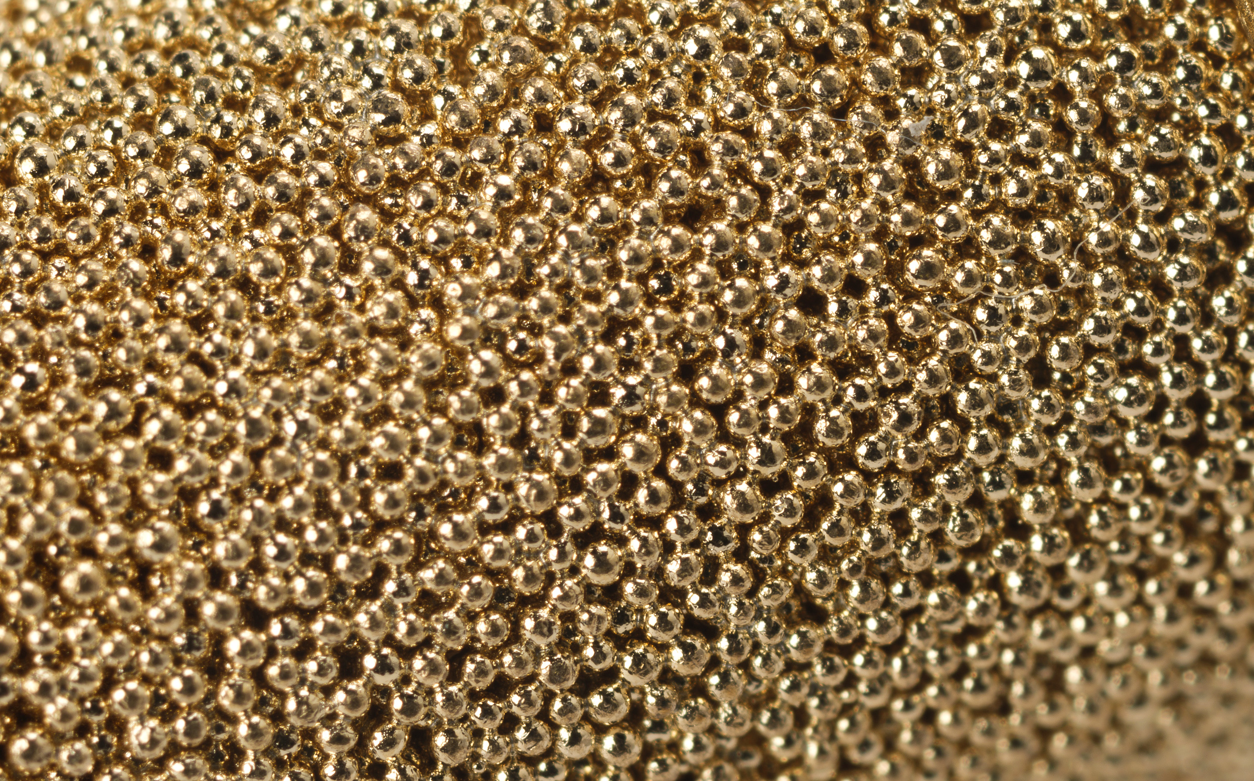 Extreme close-up productfotografie. Extreem detail van een filter. Het lijkt op een sieraad van aaneen gesmolten gouden balletjes.